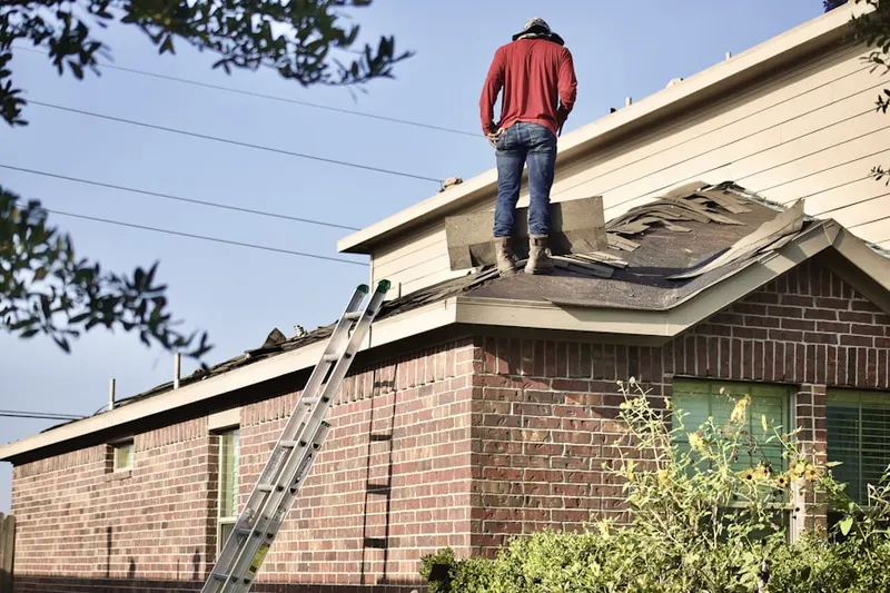 Professional roofer working on a residential roof in Davis Square